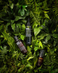 푸리토 클렌징 오일, 에센스, 세럼이 울창한 잎 배경에 놓인 이미지 Purito cleansing oil, essence, and serum placed against a lush green leaf background