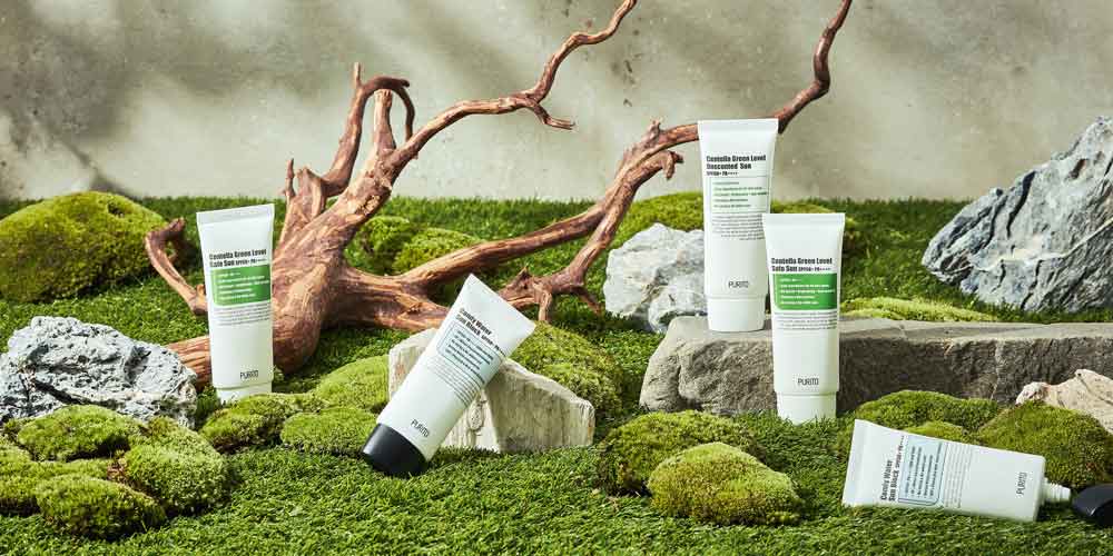 푸리토 선케어 제품이 이끼와 암석, 고사리 배경에 놓인 이미지 Purito sun protection skincare products displayed among moss and rocks