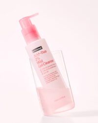 Mild gel cleanser bottle placed in a transparent glass