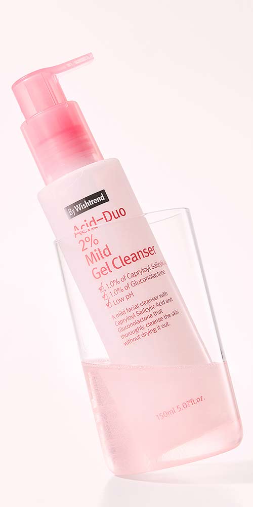 Mild gel cleanser bottle placed in a transparent glass
