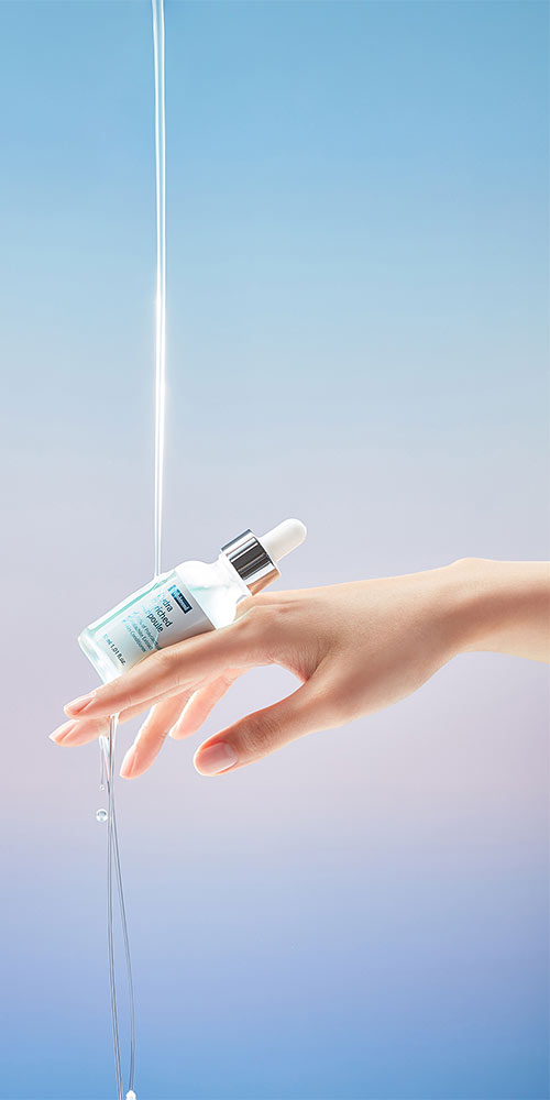 Hand holding ByWishtrend Hydra Ampoule with water stream