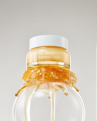 A close-up shot of balance cream jar with honey-like texture overflowing from the top