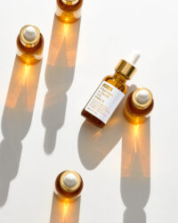 Multiple amber serum bottles casting dramatic shadows