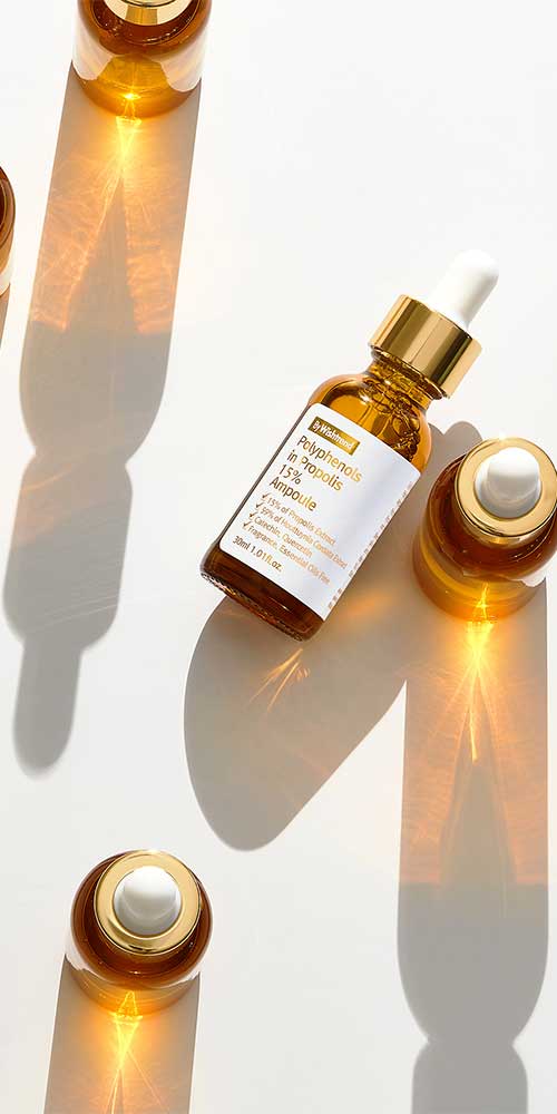 Multiple amber serum bottles casting dramatic shadows