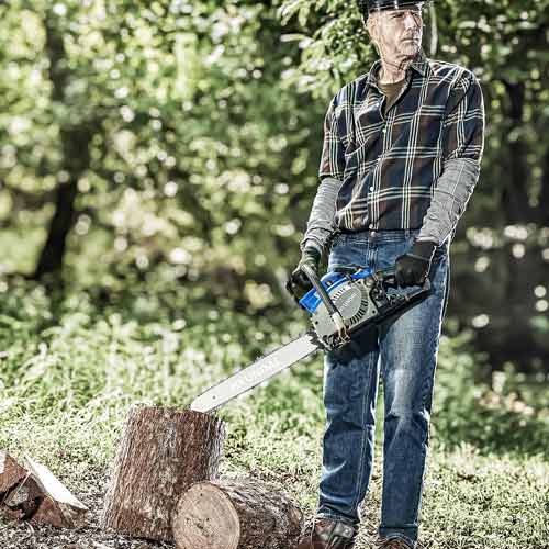 Man Holding Chainsaw Outdoors in Forest