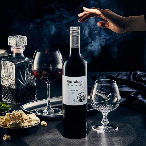 어두운 배경과 연기 속에 손이 와인병을 향해 뻗은 연출 이미지 A dramatic scene of a hand reaching toward a wine bottle surrounded by smoke and deep shadows