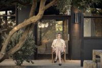 테라스 의자에 앉아 베이지 룩을 입은 모델 Model seated in beige short-sleeve top and shorts on terrace