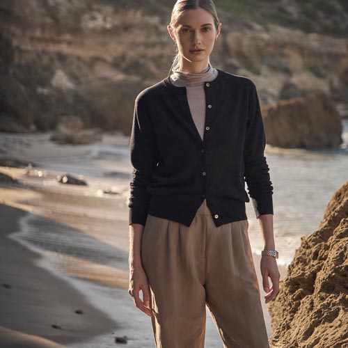 해변에서 블랙 가디건과 베이지 팬츠를 착용한 여성 모델 Woman in black cardigan and beige trousers on the beach