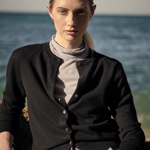 바다 앞에서 블랙 가디건과 그레이 터틀넥을 입은 여성 모델 Woman in black cardigan and gray turtleneck by the sea
