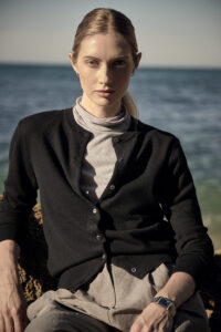 바다 앞에서 블랙 가디건과 그레이 터틀넥을 입은 여성 모델 Woman in black cardigan and gray turtleneck by the sea