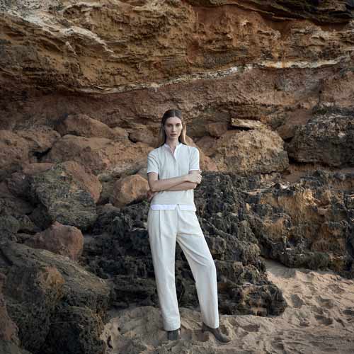 모래 해변에서 린넨 셔츠와 팬츠를 입은 여성 모델 Woman in linen shirt and pants on a rocky beach