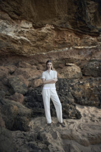 모래 해변에서 린넨 셔츠와 팬츠를 입은 여성 모델 Woman in linen shirt and pants on a rocky beach