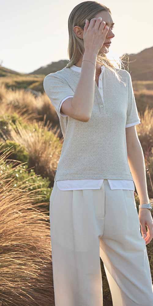 호주의 해안 초원에서 자연광을 받은 여성 모델의 골프웨어 착장 A model wearing Elune Mode golfwear in soft sunlight on an Australian coastal hill