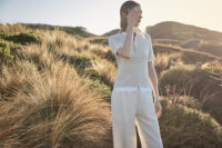 호주의 해안 초원에서 자연광을 받은 여성 모델의 골프웨어 착장 A model wearing Elune Mode golfwear in soft sunlight on an Australian coastal hill