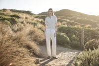 부드러운 여름 빛 아래 크림 톤 팬츠를 입은 여성 모델 Female model wearing cream trousers and minimal top in golden hourv