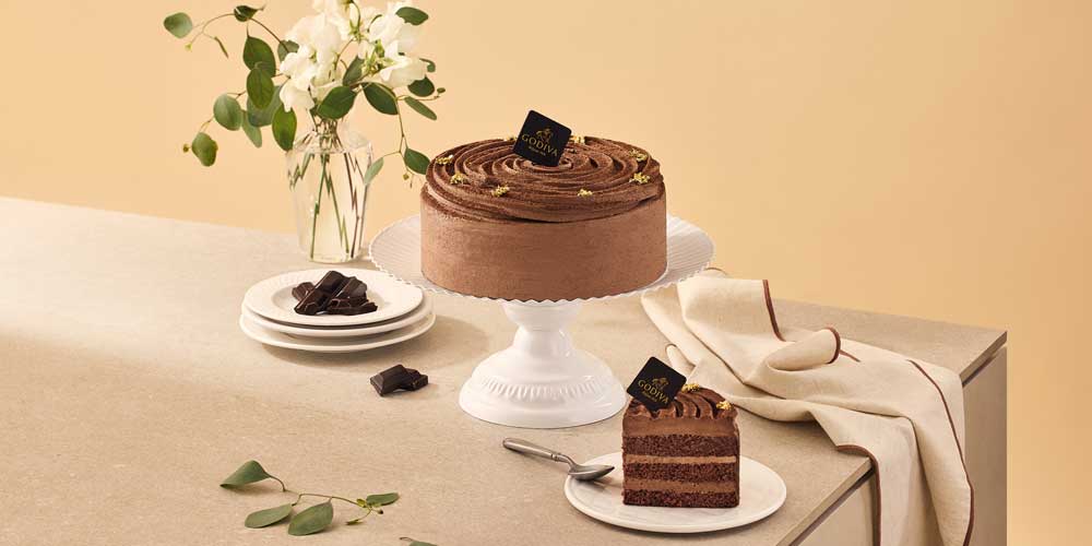 Chocolate cake with slice and plates in a studio setup