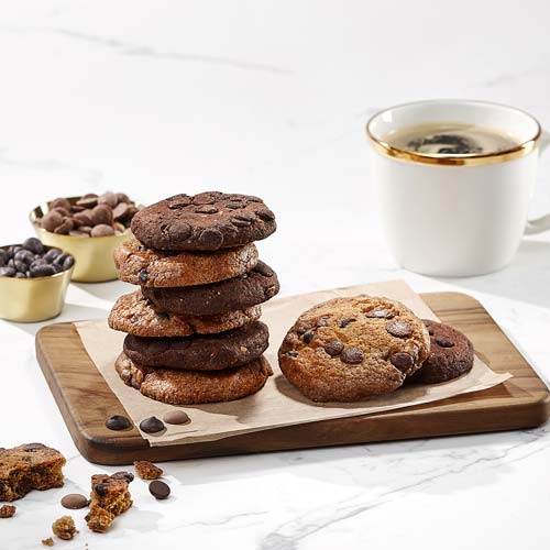 Stack of chocolate chip cookies with a coffee cup on marble table