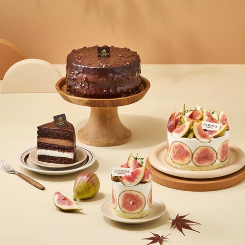 Two whole cakes and a sliced piece with fresh figs and chocolate