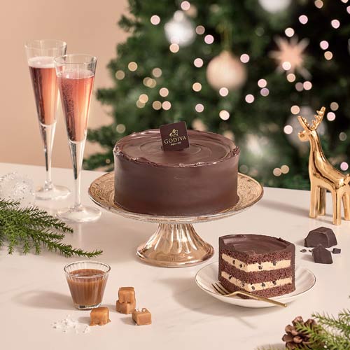 Chocolate layer cake with holiday ornaments and champagne