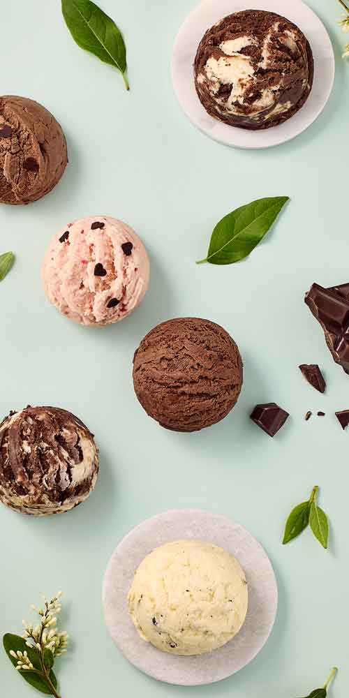 Godiva ice cream scoops in various flavors on mint background