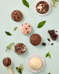 Godiva ice cream scoops in various flavors on mint background