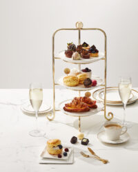 Elegant studio photo of a four-tier Godiva dessert set with drinks