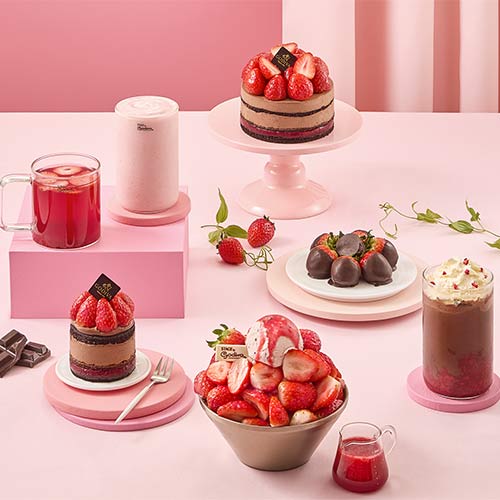 Assorted Godiva strawberry desserts and beverages on a pink table