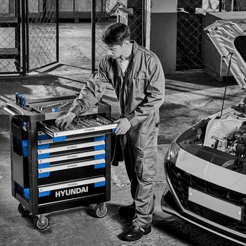 공구함 앞에서 차량을 점검 중인 정비사 Mechanic inspecting car and organizing tool cart