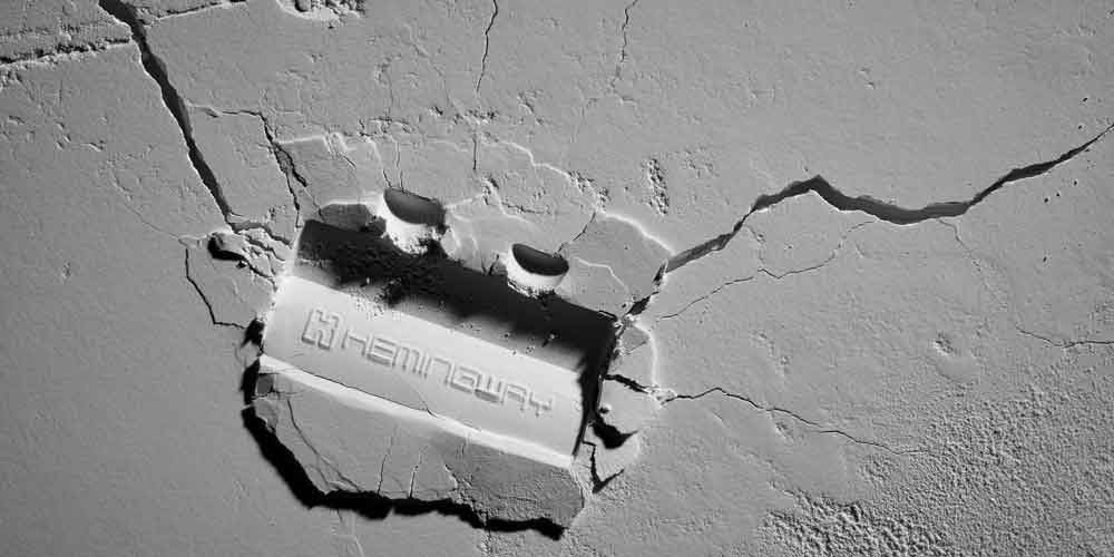 깨진 석고 위에 눌린 Hemingway 로고 클로즈업 이미지 Close-up of Hemingway logo embedded in cracked plaster
