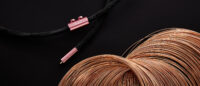 검은 배경 위 Z-core Σ 오디오 케이블과 펼쳐진 구리선 Z-core Σ audio cable with exposed copper wire on black background