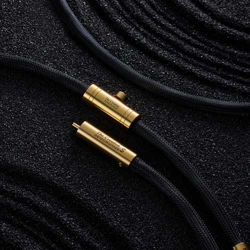 헤밍웨이 Creation S RCA 오디오 케이블 Hemingway gold RCA cable on black grainy background