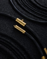 헤밍웨이 Creation S RCA 오디오 케이블 Hemingway gold RCA cable on black grainy background