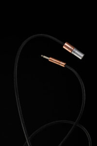 암전 배경에서 곡선을 그리는 PRO TS·XLR 케이블 PRO series TS and XLR cable arcing across black backdrop