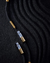 XLR 및 RCA 단자가 연결된 오디오 케이블 XLR and RCA audio cables on black textured sand