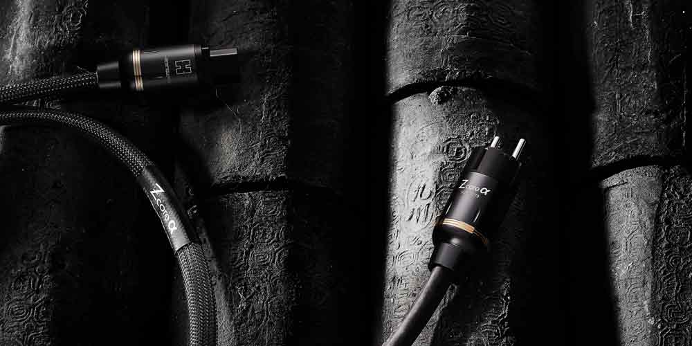 질감 있는 검은 배경 위에 놓인 Z-core α 오디오 케이블 Z-core α audio cable on traditional black carbon surface