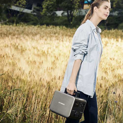 Woman Holding battery pack in Field