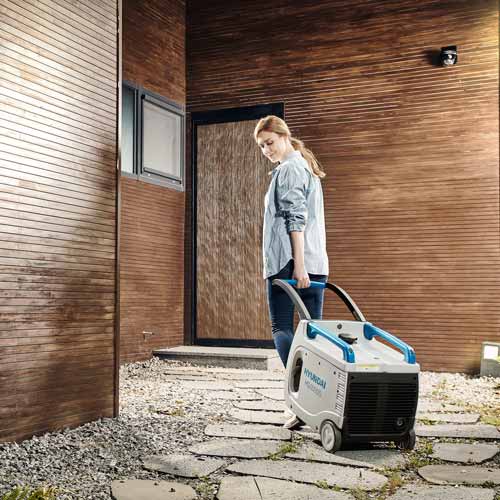 전동 장비를 실외로 이동시키는 인물 중심의 광고 사진 포트폴리오 Woman moving a power device outside in lifestyle product portfolio photo
