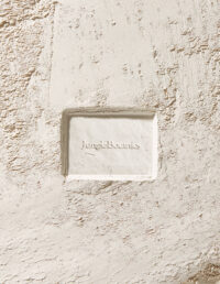 거친 질감의 벽면에 끼워진 Jungle Botanics 비누 정면 Front view of Jungle Botanics soap inserted in a rough-textured wall