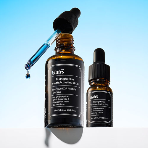 푸른 액상이 떨어지는 Klairs 앰플 제품 클로즈업 이미지 Still life of Klairs blue serum with dropper in motion over light sky background