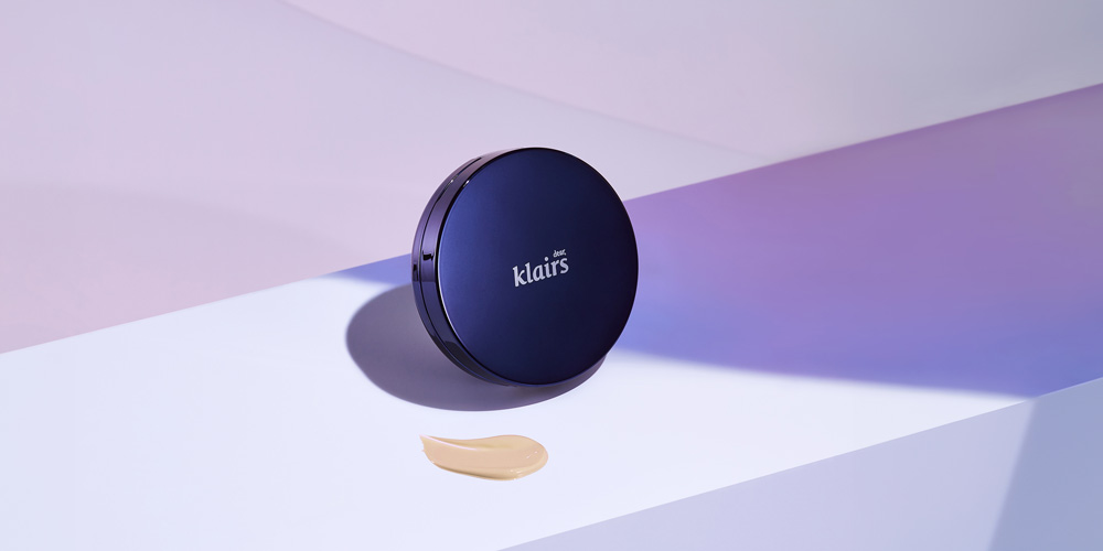 클레어스 쿠션 제품이 섬세한 그림자와 함께 배치된 모습 Klairs cushion compact with subtle shadows and base texture