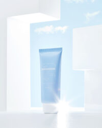 파란 하늘 배경 안에 단독 배치된 Klairs 선크림 제품 이미지 Still life of Klairs blue sunscreen product with clean sky background and white framing