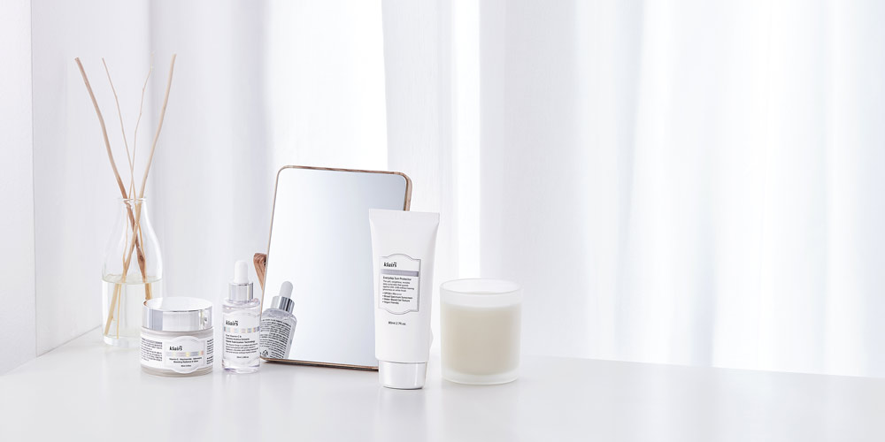 화이트 톤 배경 위에 구성된 클레어스 기초 제품 이미지 Klairs skincare routine products staged on clean white surface with mirror and diffuser
