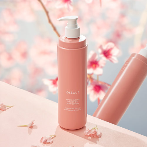 벚꽃 배경 위에 오제끄 피치 플라워 바디로션이 놓여 있는 제품 사진 Product shot of Oseque Peach Flower Body Lotion placed in front of cherry blossom backdrop