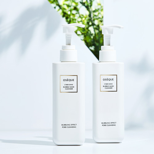 오제끄 클렌저 2종이 화사한 자연광과 초록 식물 그림자 배경에서 연출된 이미지 Two Oseque Cyber Shine Cleansers arranged on white surface with leafy shadows