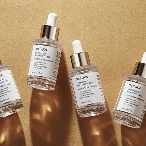 빛과 그림자가 강조된 바닥 위에 배치된 오제끄 하이드레이팅 스킨 퍼펙터 앰플 4개 Four Oseque Hydrating Skin Perfector Ampoules placed on warm-toned textured surface