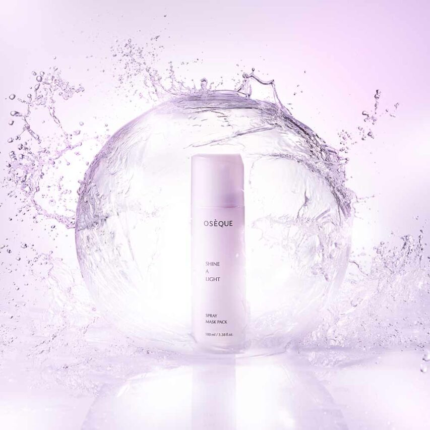 보랏빛 물방울 속에 둘러싸인 오제끄 샤인 어 라이트 마스크팩 연출 이미지 Shining mist maskpack encased in a burst of purple-tinted water sphere