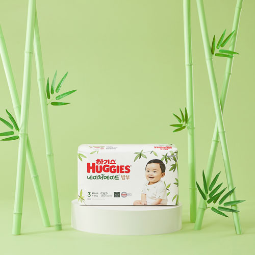 밝은 녹색 배경과 하기스 기저귀 제품을 강조한 제품 사진 Product photo of Huggies bamboo diapers with baby model in green set