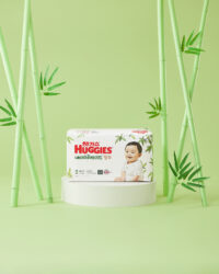 밝은 녹색 배경과 하기스 기저귀 제품을 강조한 제품 사진 Product photo of Huggies bamboo diapers with baby model in green set