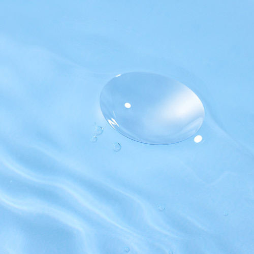 투명 콘택트렌즈가 맑은 물 위에 떠 있는 이미지 Image of a clear contact lens gently floating on water