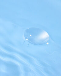 투명 콘택트렌즈가 맑은 물 위에 떠 있는 이미지 Image of a clear contact lens gently floating on water